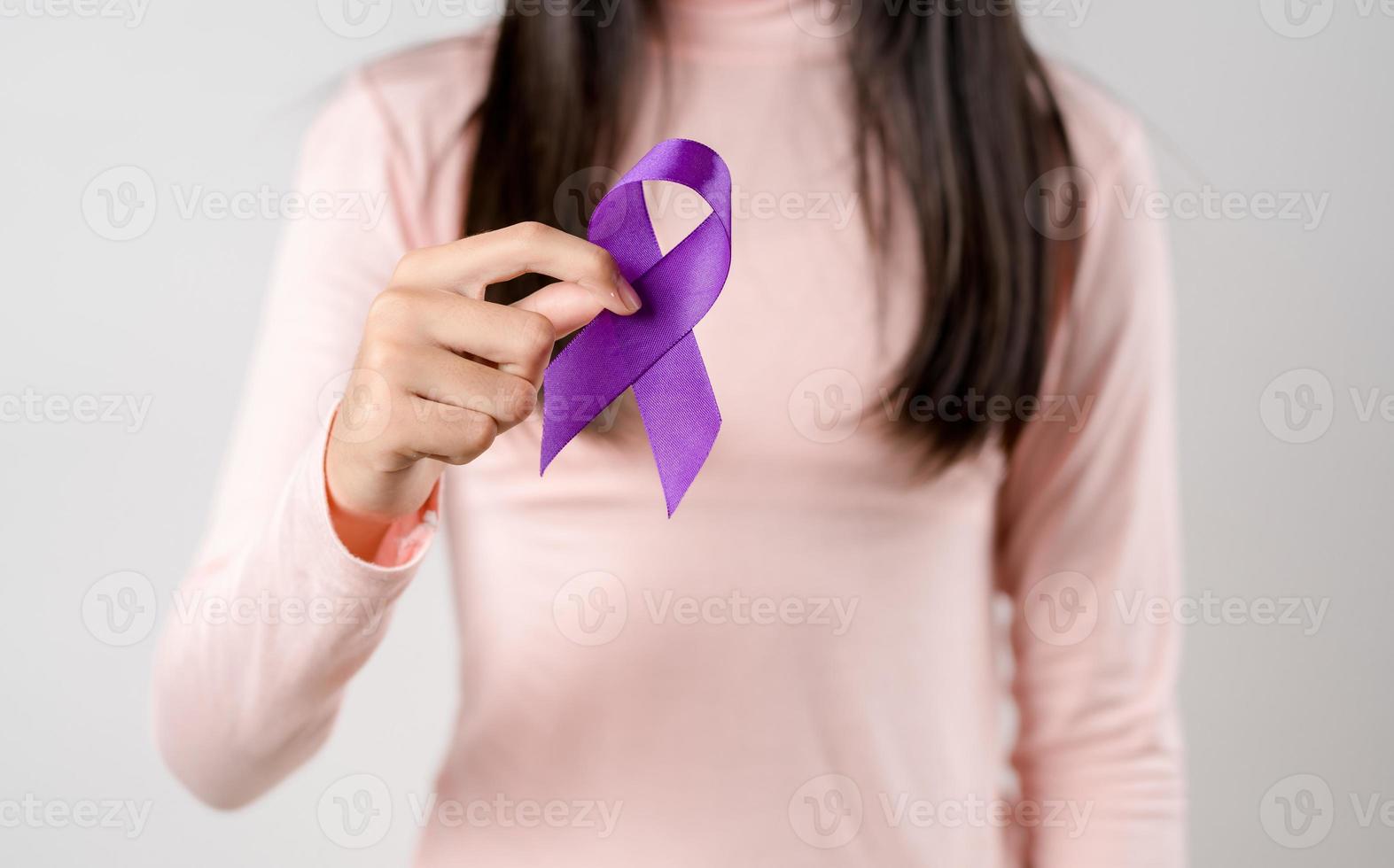woman hands holding purple ribbon, Alzheimer disease, Pancreatic cancer, Epilepsy awareness, world cancer day on a purple colored background, World Cancer Day concept photo