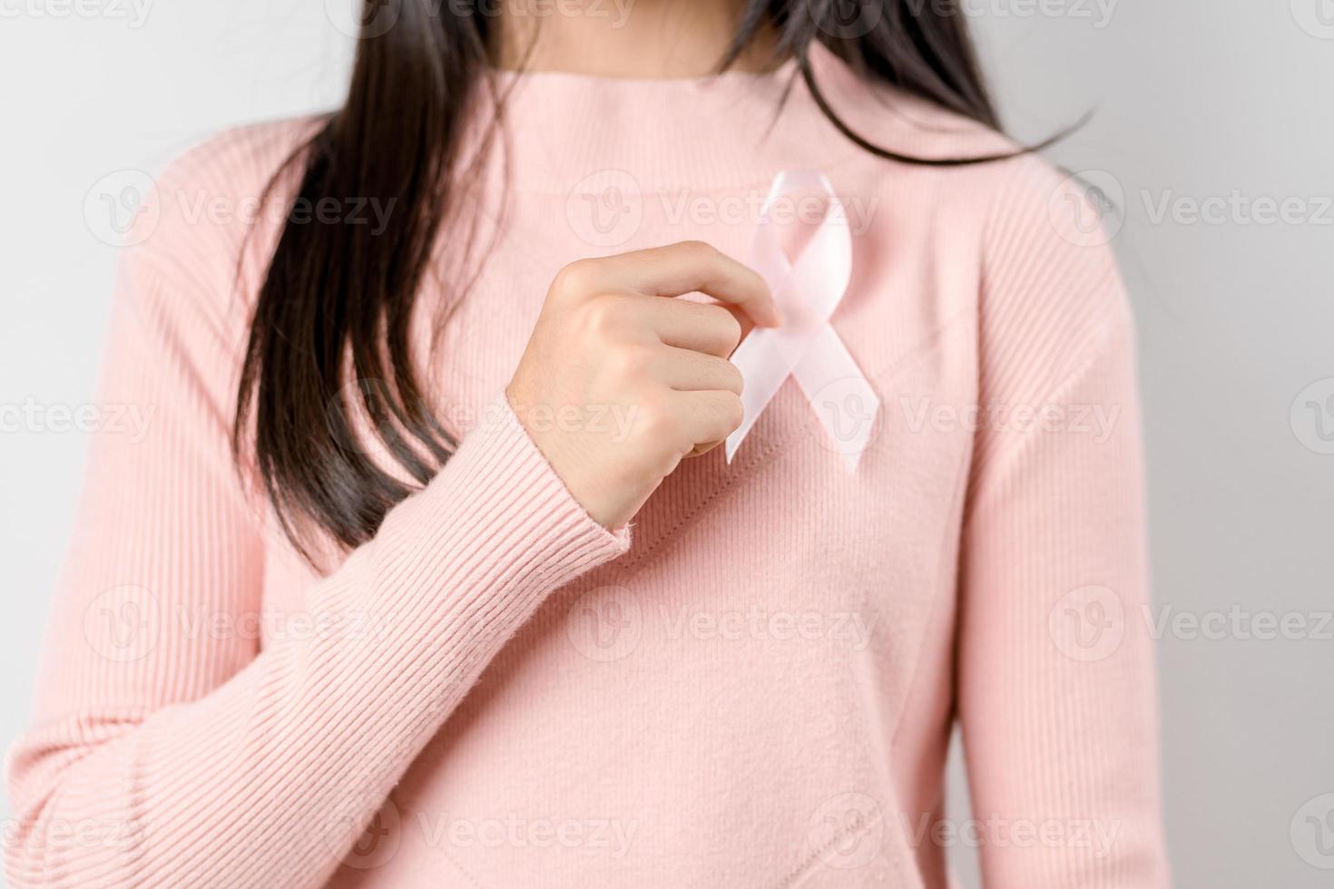 happy woman showing pink ribbons, Breast cancer awareness, world cancer day, national cancer survivor day in february concept. photo