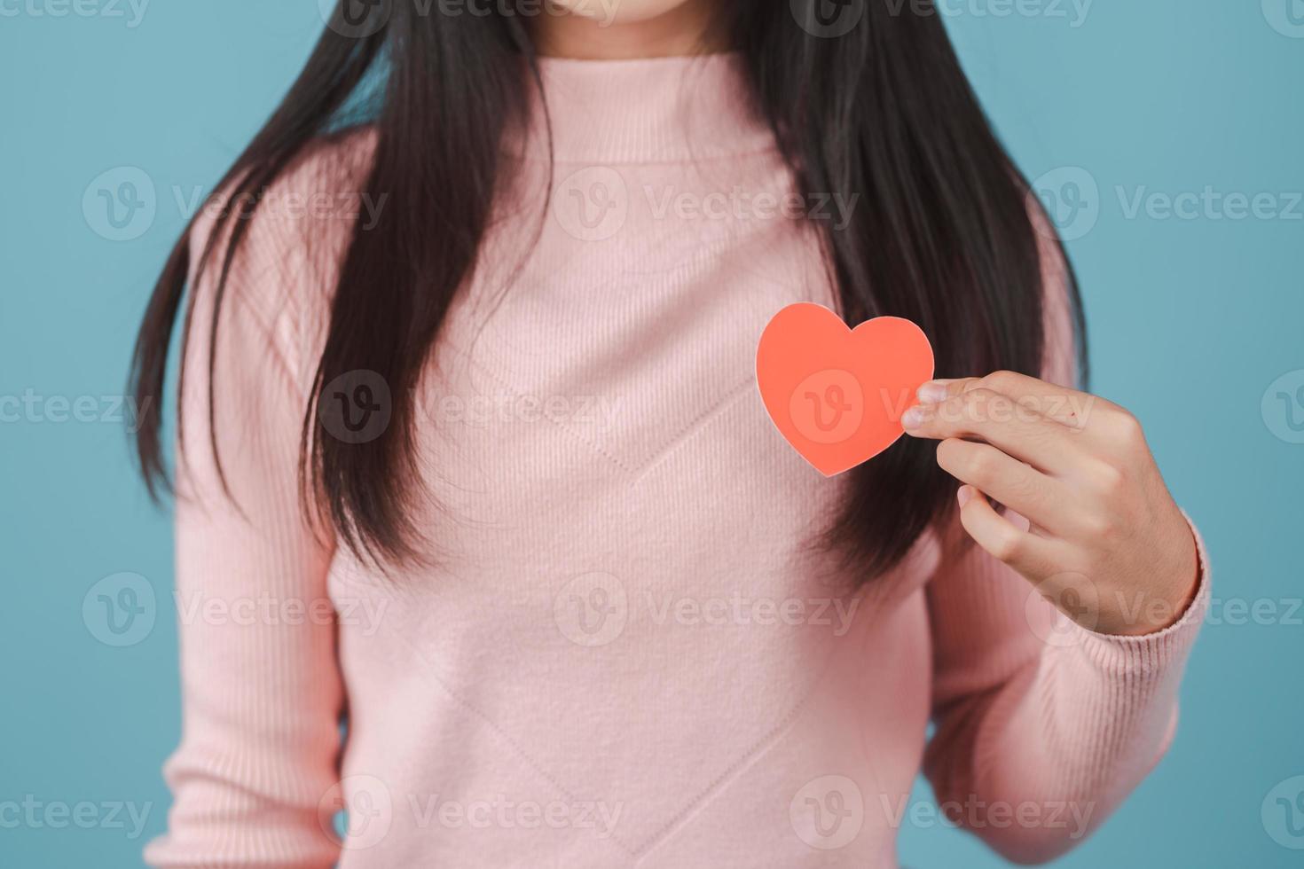 woman holding heart anatomy paper cut, heart attack, heart disease, Female with health care and Healthy feminine, World Heart Day concept. photo
