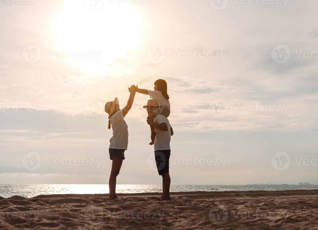 contento asiático familia disfrutar el mar playa a consistente padre, madre y hija teniendo divertido jugando playa en verano vacaciones en el Oceano playa. contento familia con vacaciones hora estilo de vida concepto. foto