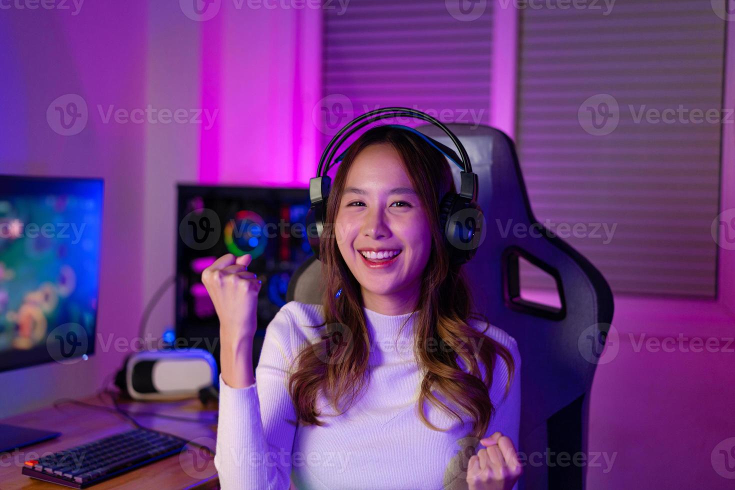 Asian gamer playing online video game winning excited on PC with lighting effect, broadcast streaming live at home. Gamer and E-Sport online gaming technology Championship tournament gamer concept. photo