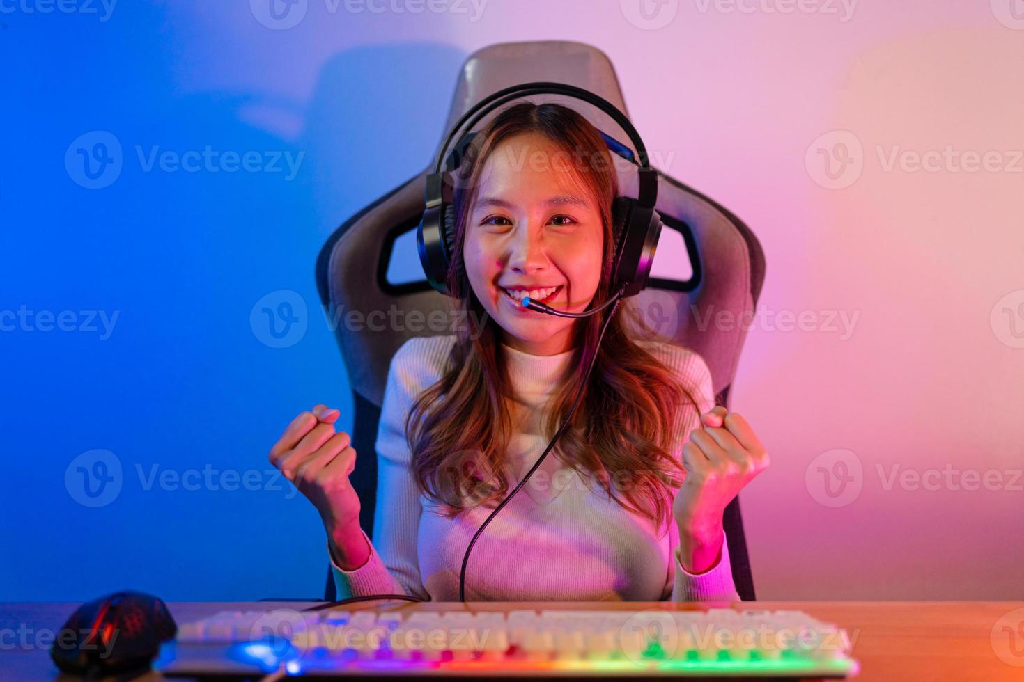 Asian gamer playing online video game winning excited on PC with lighting effect, broadcast streaming live at home. Gamer and E-Sport online gaming technology Championship tournament gamer concept. photo