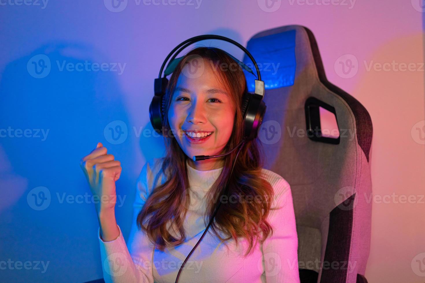 Asian gamer playing online video game winning excited on PC with lighting effect, broadcast streaming live at home. Gamer and E-Sport online gaming technology Championship tournament gamer concept. photo