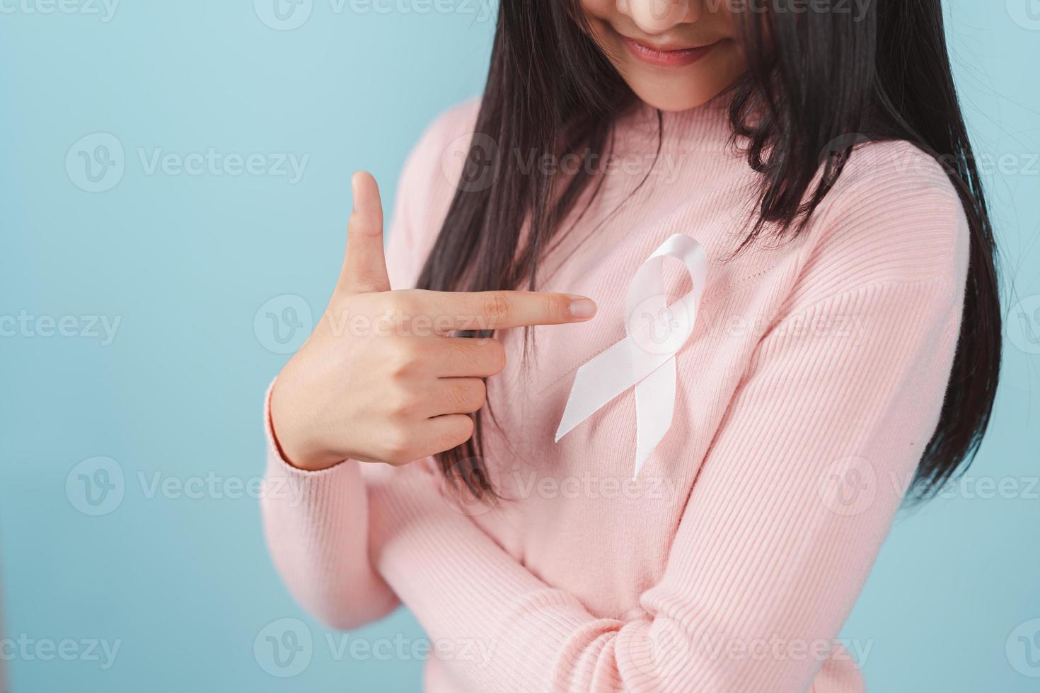 happy woman showing pink ribbon, Breast cancer awareness, world cancer day, national cancer survivor day in february concept. photo