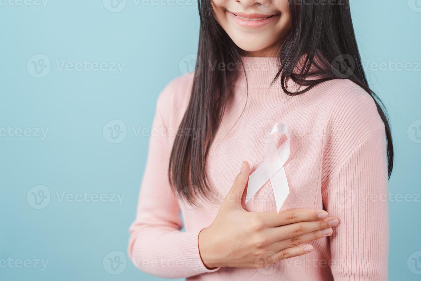 happy woman showing pink ribbon, Breast cancer awareness, world cancer day, national cancer survivor day in february concept. photo