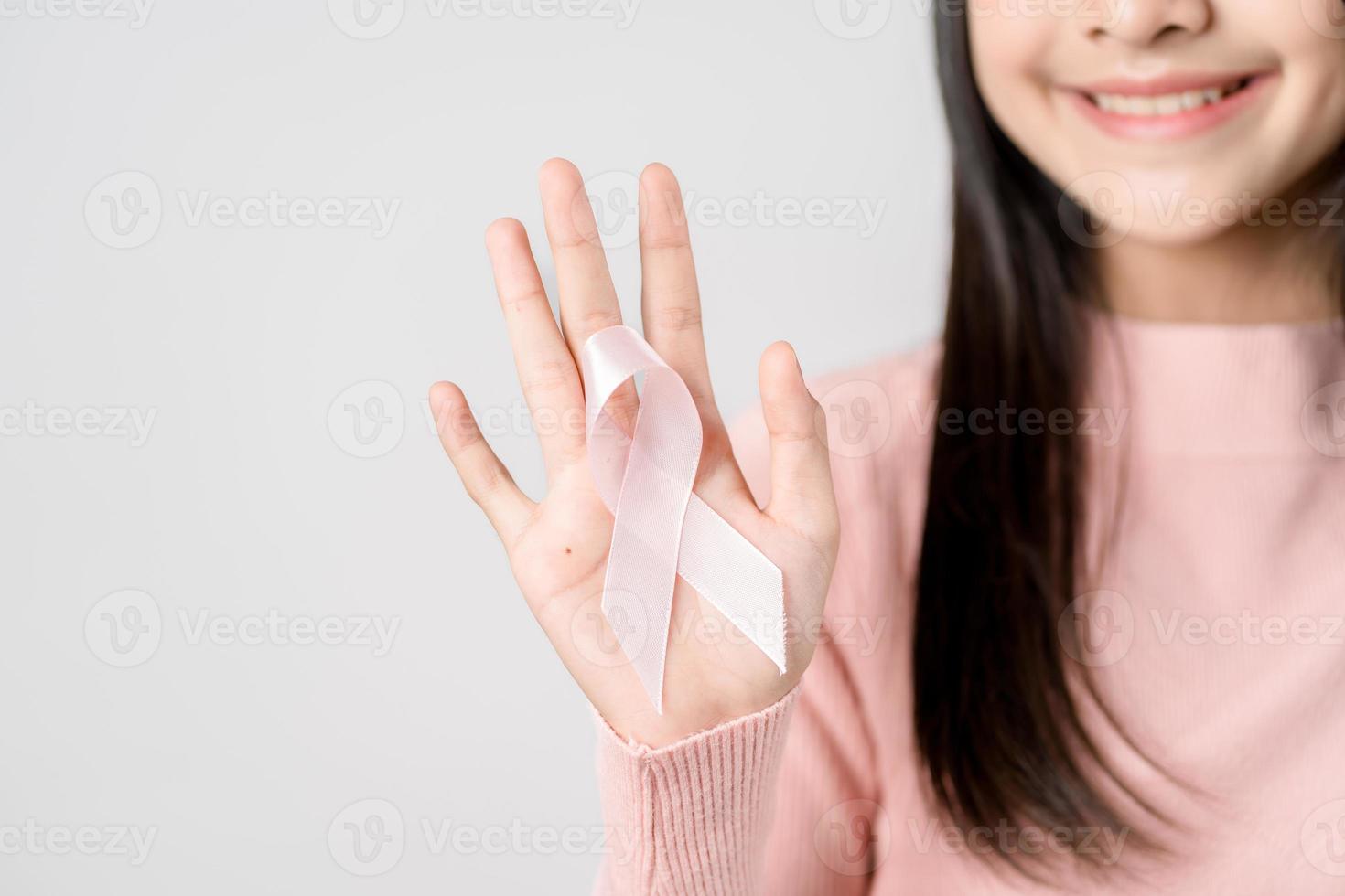 happy woman showing pink ribbons, Breast cancer awareness, world cancer day, national cancer survivor day in february concept. photo