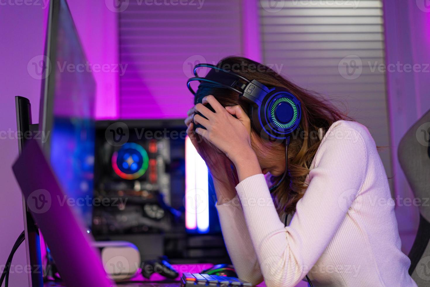 Happy professional player streaming esport tournament using microphone and  headphones, enjoying a multiplayer game. Competitive gamer playing online  video game at home. Neon color. Cyber sport concept Stock Photo