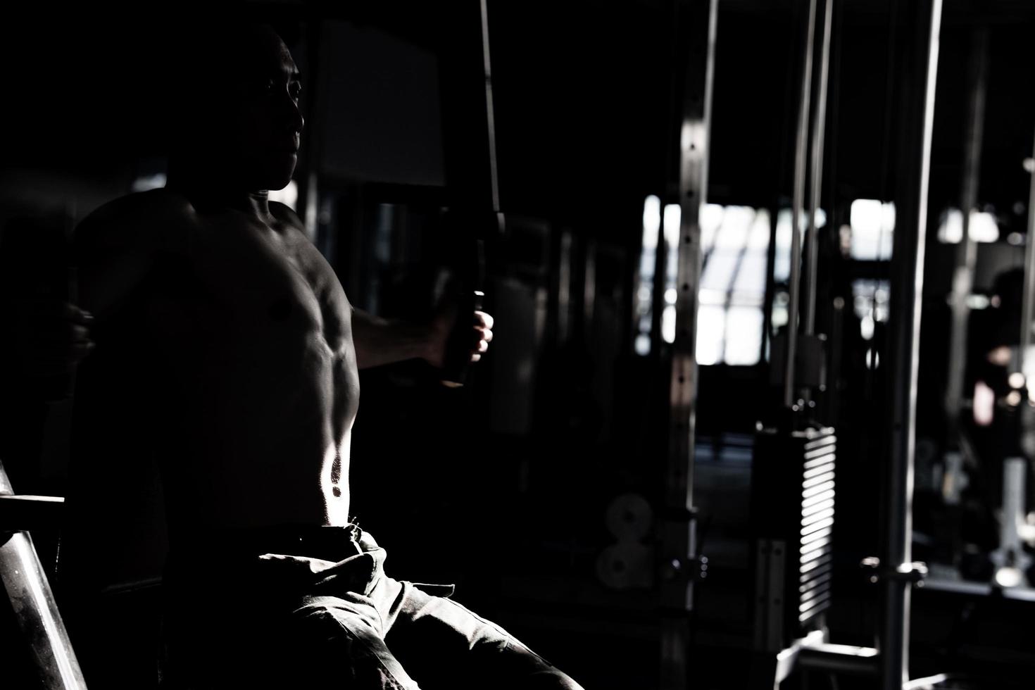 Sexy body of muscular young Asian man in gym. Concept of health care, exercise fitness, Strong muscle mass, body enhancement, fat reduction for men's health supplement product presentation. photo