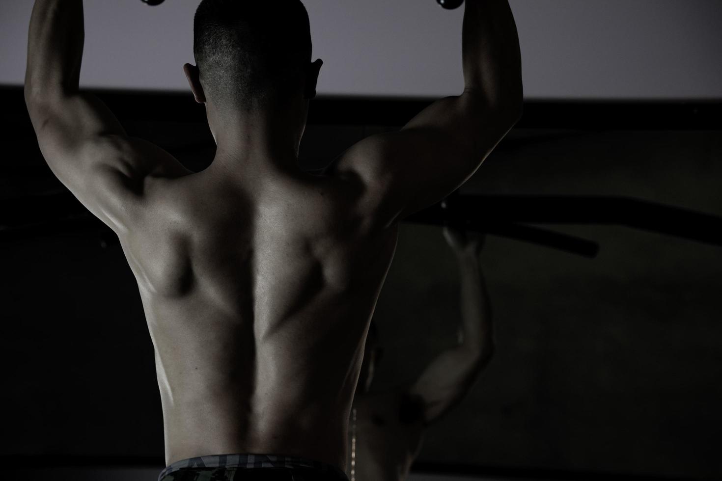Sexy body of muscular young soldier Asian man in gym. Concept of health care, exercise fitness, Strong muscle mass, body enhancement, fat reduction for men's health supplement product presentation. photo