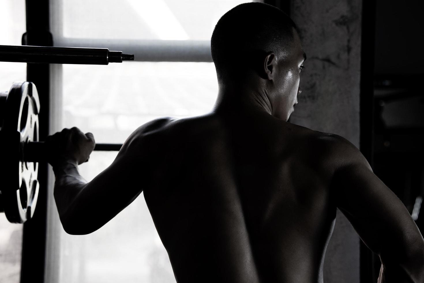 Sexy body of muscular young soldier Asian man in gym. Concept of health care, exercise fitness, Strong muscle mass, body enhancement, fat reduction for men's health supplement product presentation. photo