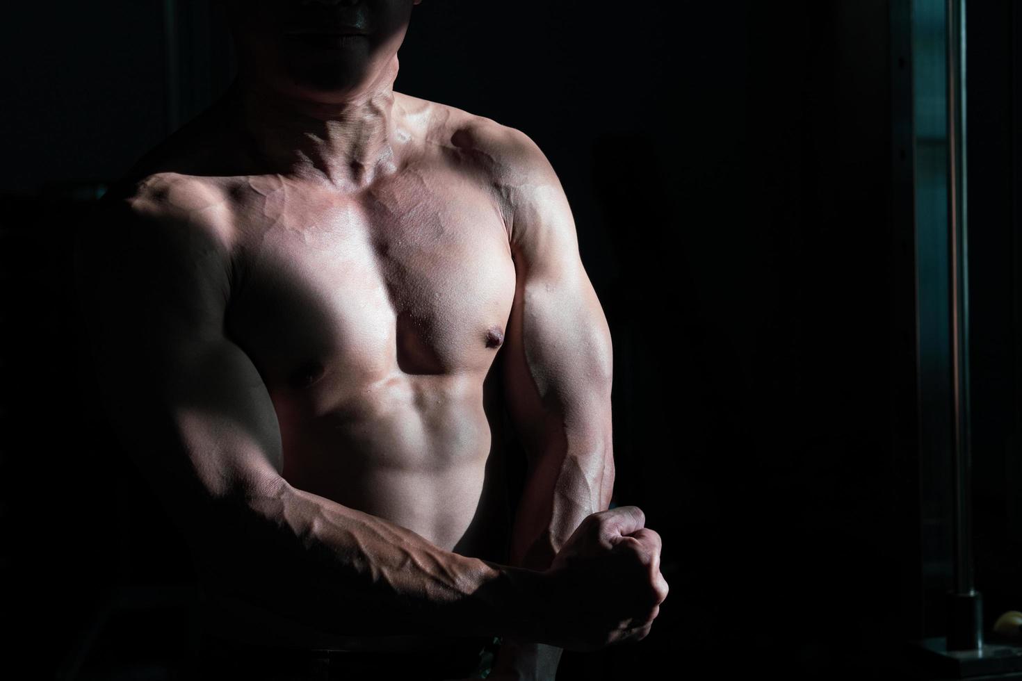 Sexy body of muscular young soldier Asian man in gym. Concept of health care, exercise fitness, Strong muscle mass, body enhancement, fat reduction for men's health supplement product presentation. photo