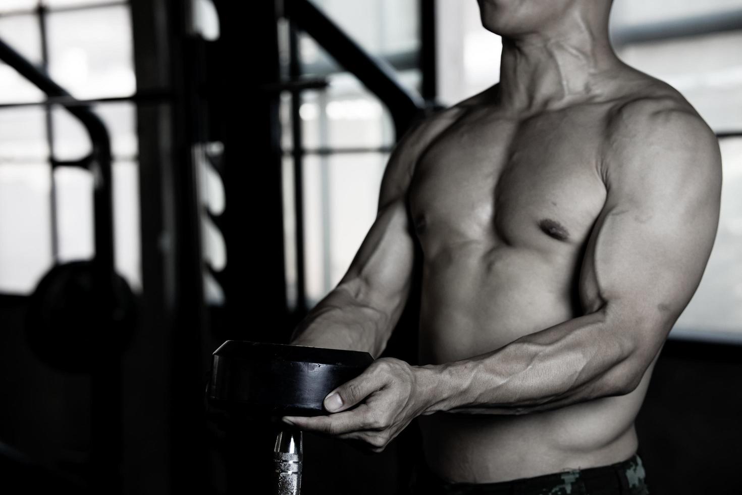 Sexy body of muscular young soldier Asian man in gym. Concept of health care, exercise fitness, Strong muscle mass, body enhancement, fat reduction for men's health supplement product presentation. photo