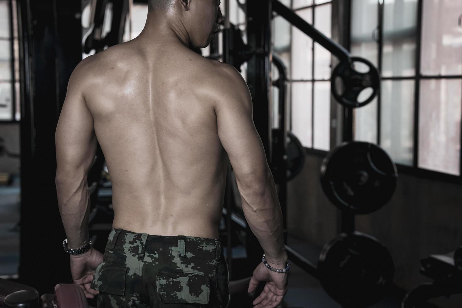 sexy cuerpo de muscular joven soldado asiático hombre en gimnasia. concepto de salud cuidado, ejercicio aptitud física, fuerte músculo masa, cuerpo mejora, grasa reducción para de los hombres salud suplemento producto presentación. foto