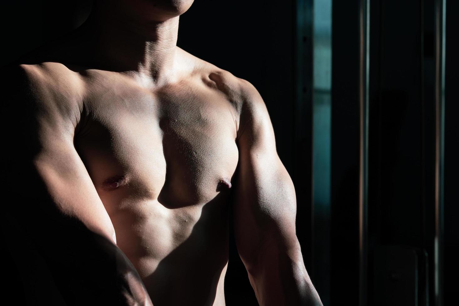 Sexy body of muscular young soldier Asian man in gym. Concept of health care, exercise fitness, Strong muscle mass, body enhancement, fat reduction for men's health supplement product presentation. photo