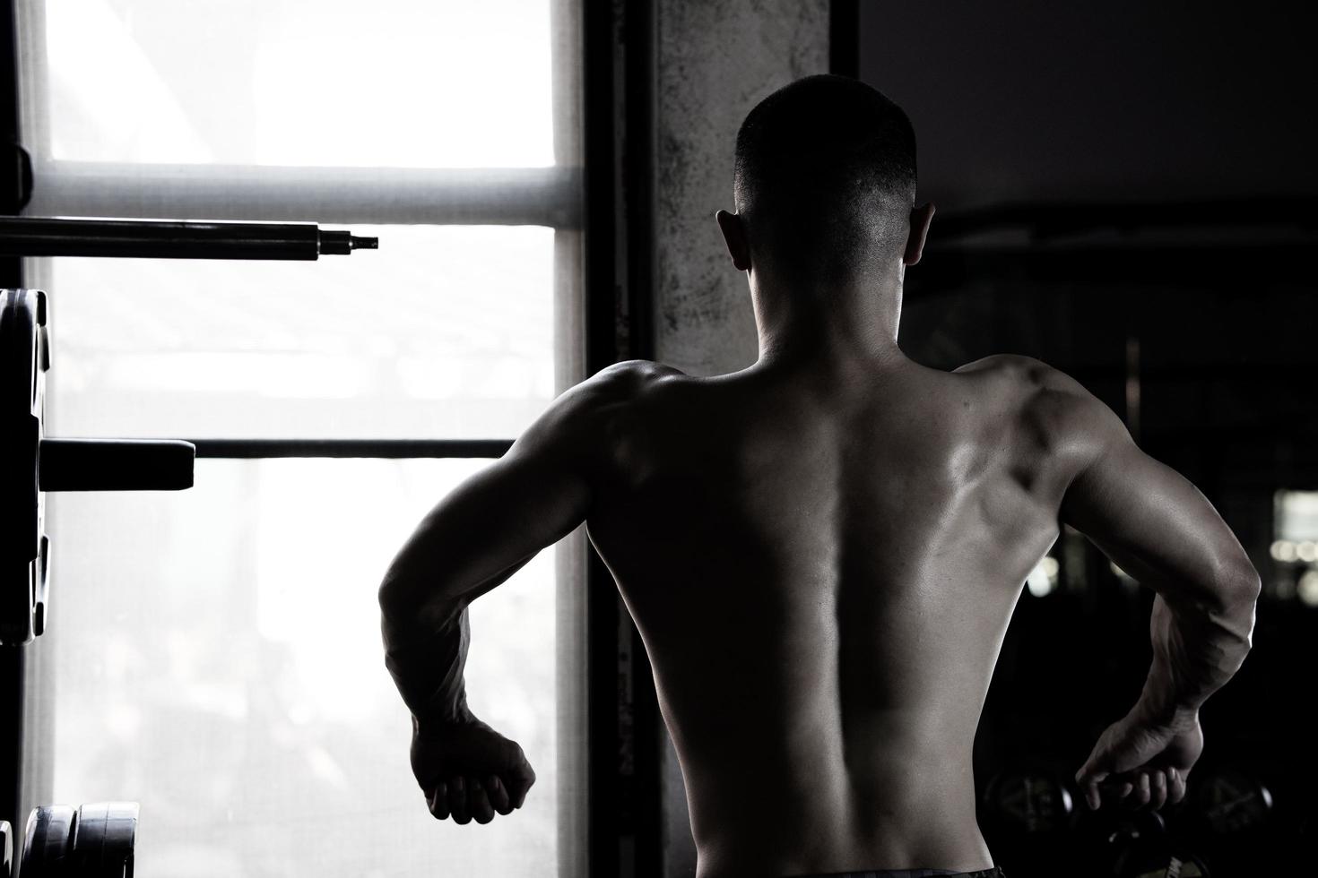 Sexy body of muscular young soldier Asian man in gym. Concept of health care, exercise fitness, Strong muscle mass, body enhancement, fat reduction for men's health supplement product presentation. photo