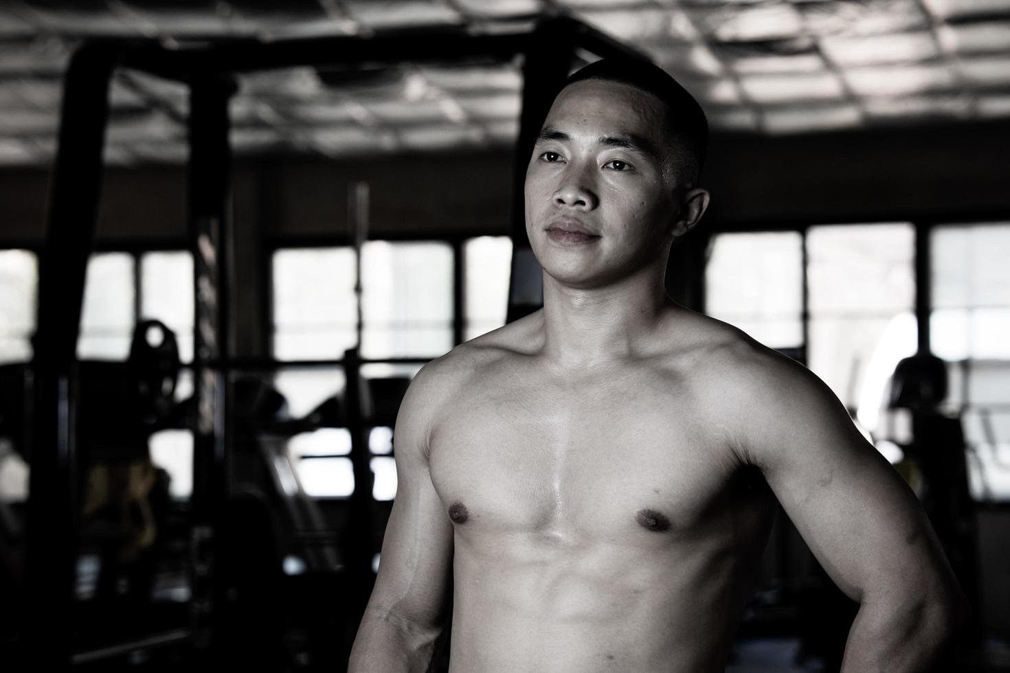 Sexy body of muscular young soldier Asian man in gym. Concept of health care, exercise fitness, Strong muscle mass, body enhancement, fat reduction for men's health supplement product presentation. photo