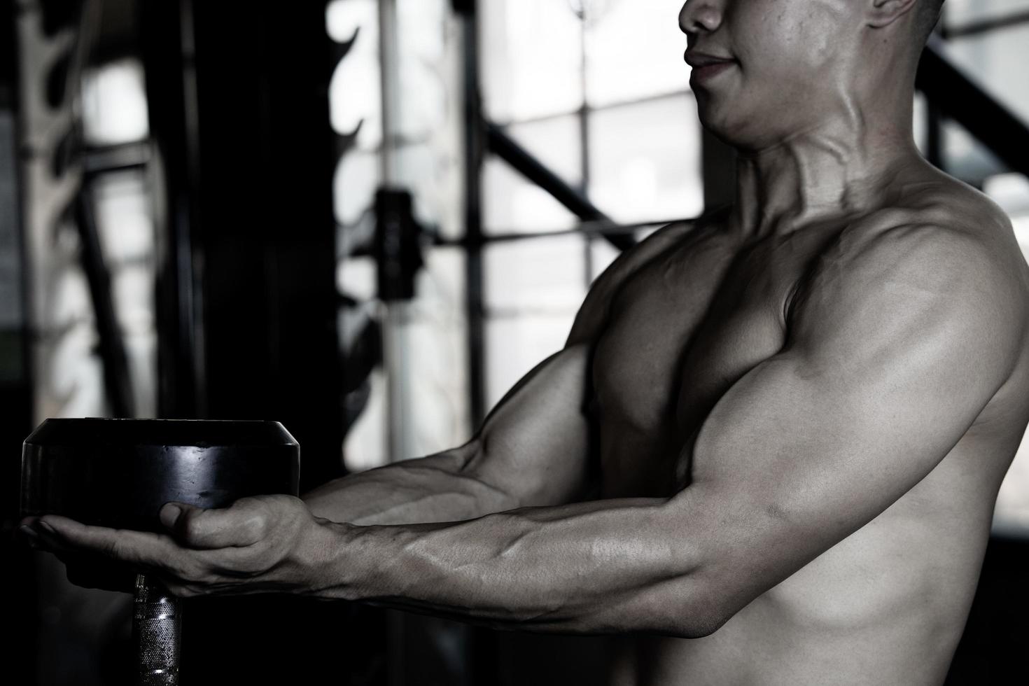 Sexy body of muscular young soldier Asian man in gym. Concept of health care, exercise fitness, Strong muscle mass, body enhancement, fat reduction for men's health supplement product presentation. photo