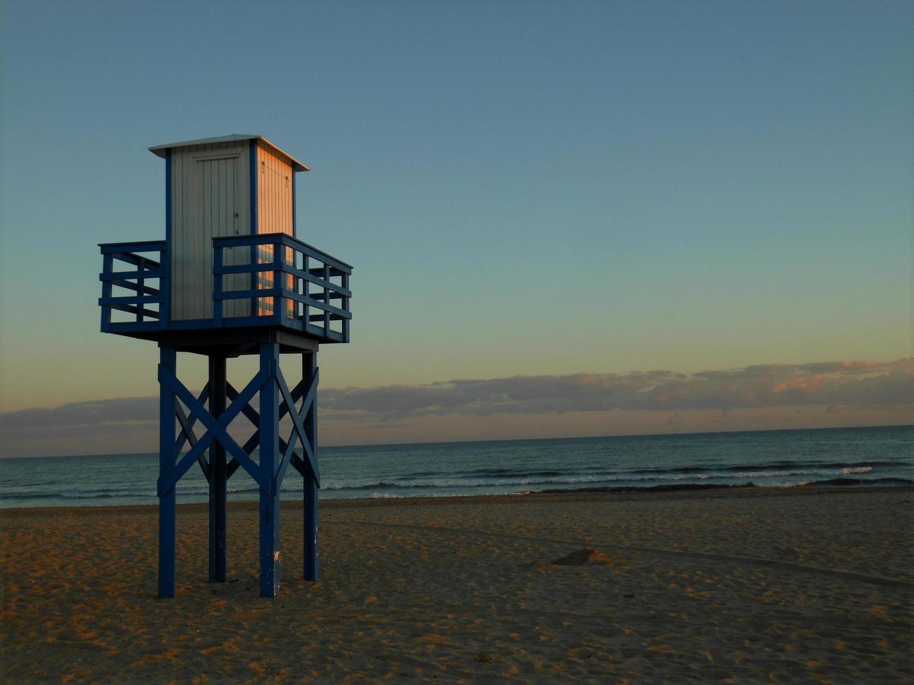 torre de vigilancia a puesta de sol en el apuntalar de el playa. foto