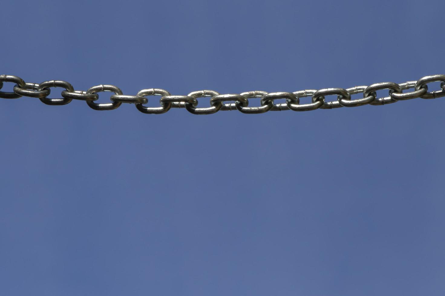 metal chain hanging against blue sky photo