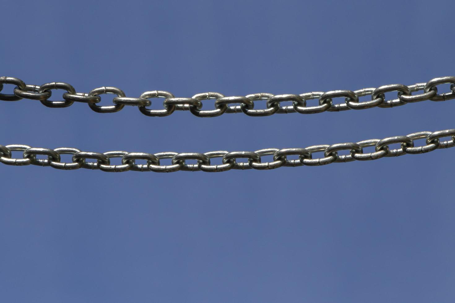 two chains hanging against blue sky photo