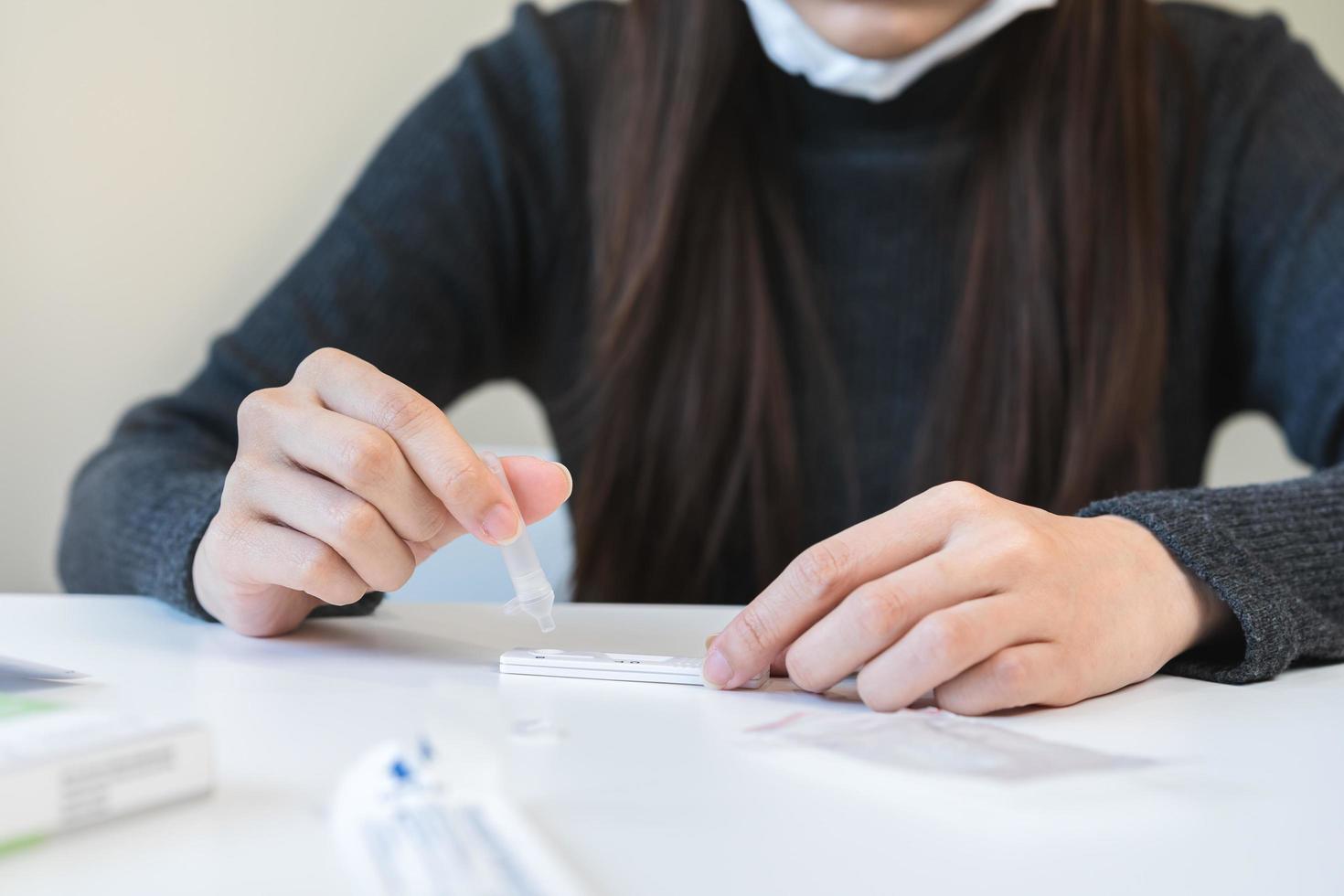 Pandemic of disease, asian young woman, girl hand holding atk, antigen kit self test. Introducing device nasal, nose swab test for possible infection of coronavirus, covid-19 at home. Health care. photo
