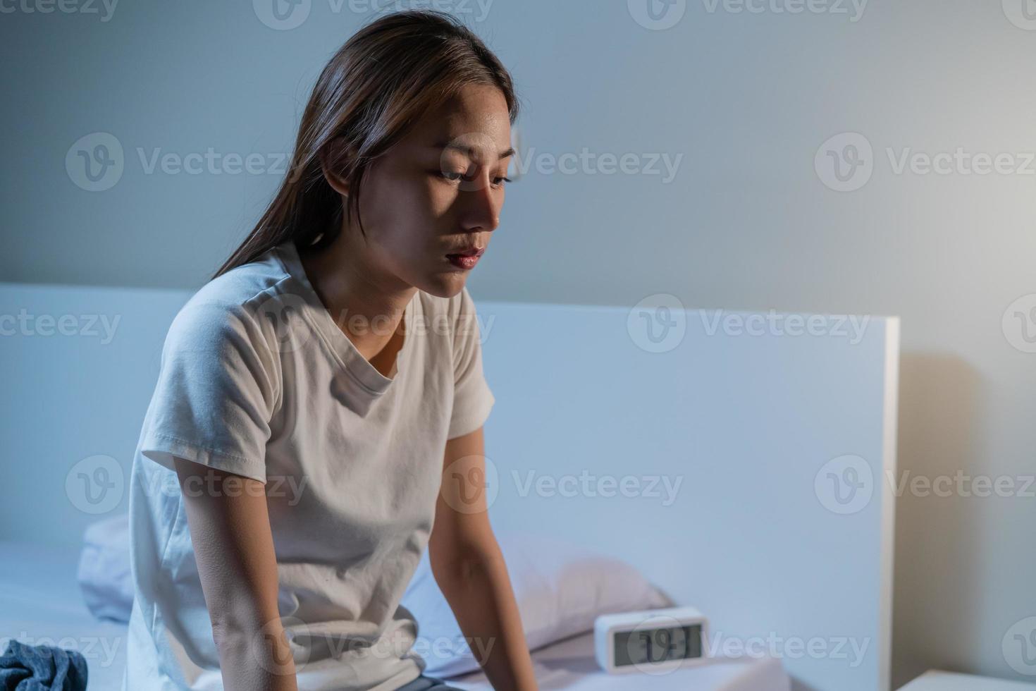Sad worried and stressed, asian young beautiful, pretty woman, girl suffering from insomnia, awake in the night in bedroom, tired and exhausted. Frustrated people with problem, exhausted on nightmares photo