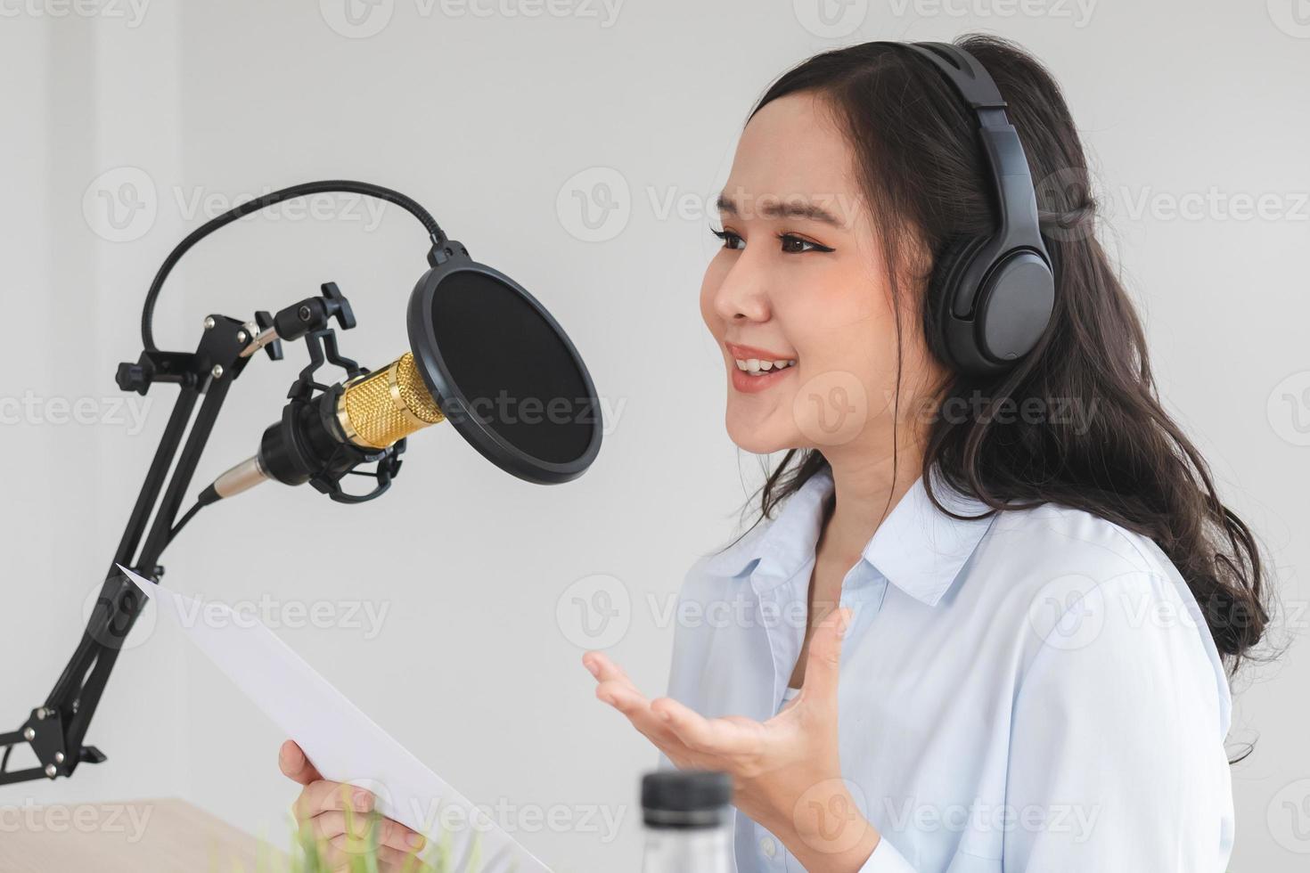 Beautiful asian young woman radio host working, setting microphone, preparing to speak before recording podcast and live on social media. Technology of on-air online in broadcasting at home studio. photo