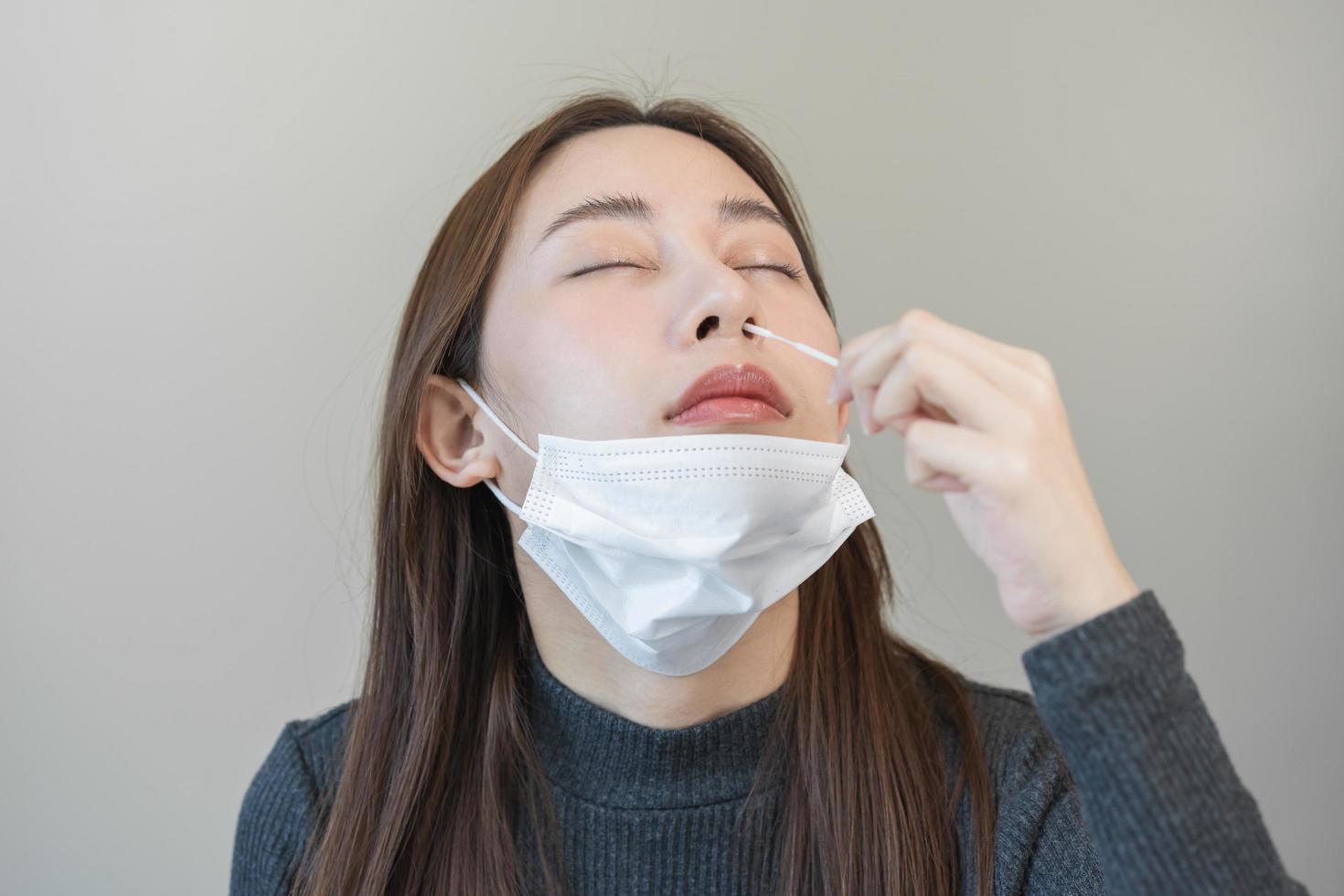 Pandemic of disease, asian young woman, girl hand holding atk, antigen kit self test. Introducing device nasal, nose swab test for possible infection of coronavirus, covid-19 at home. Health care. photo