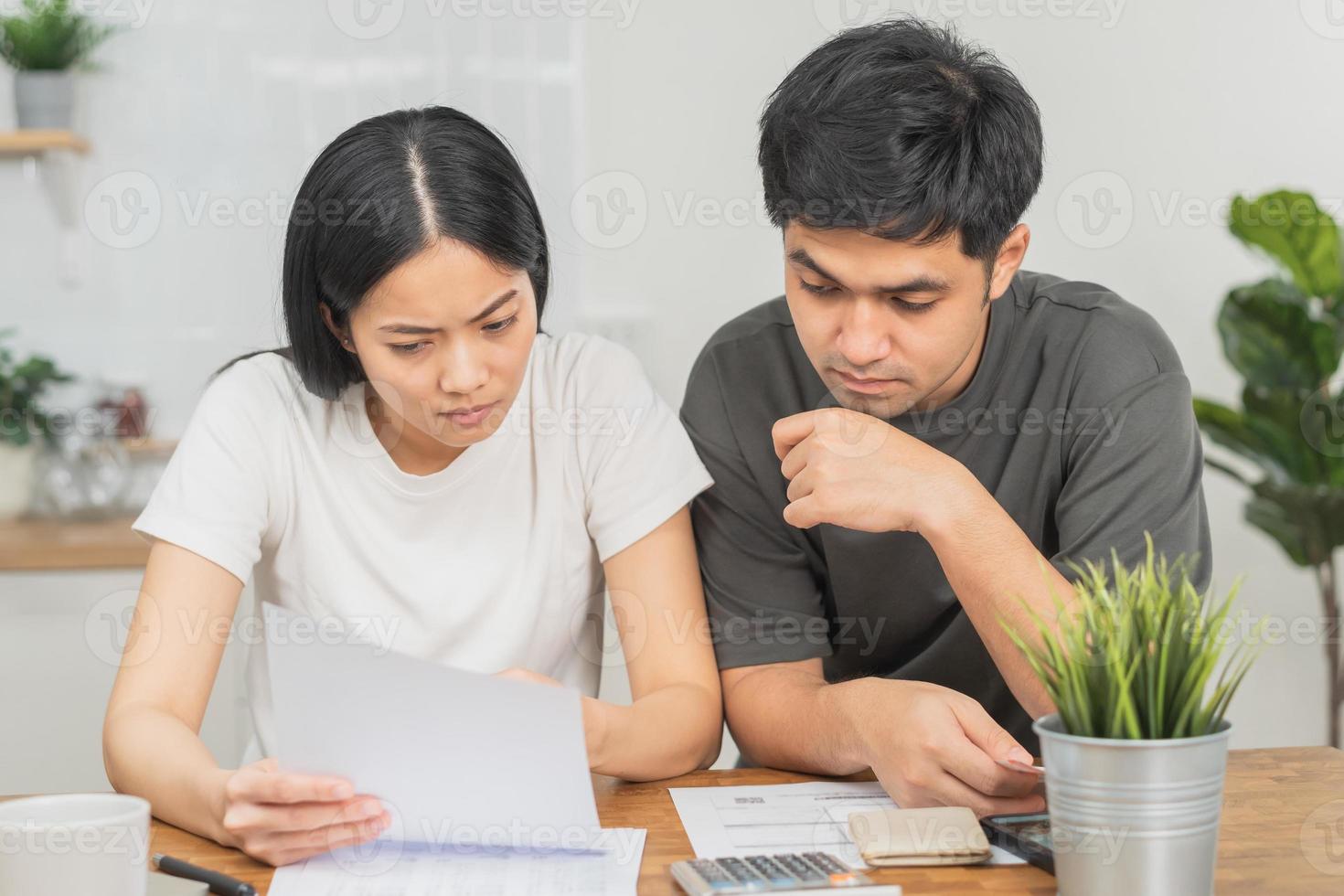 Stressed asian young couple family, wife and husband confused by calculate expense from invoice or bill, have no money to pay. Mortgage, loan causing debt, bankruptcy. Debt problems, Financial people. photo