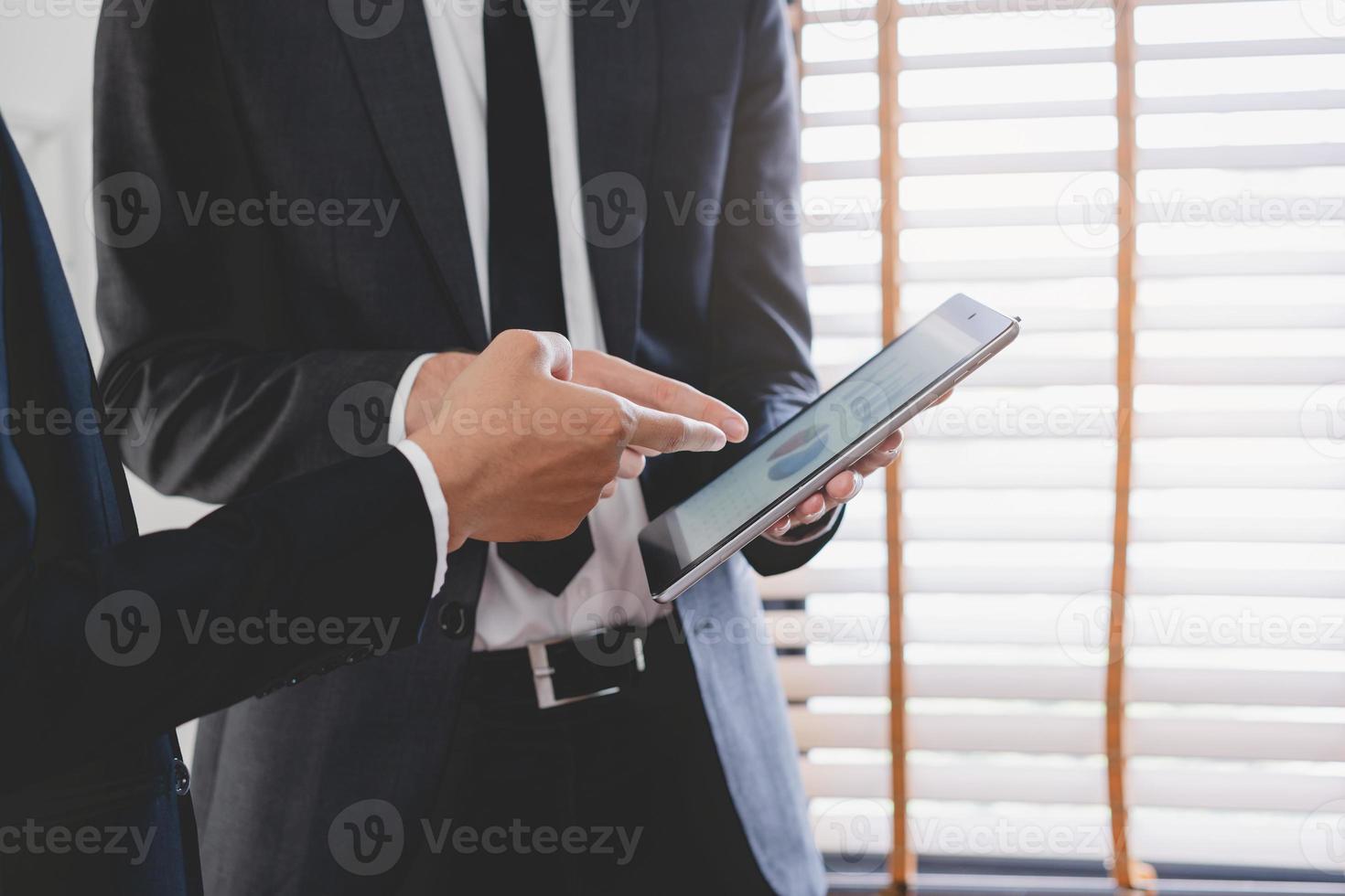 Business meeting, two caucasian, asian group man use tablet brainstorm analyzing on graph data of cost plan or document, paperwork and discussing in board room on table. People working conference room photo