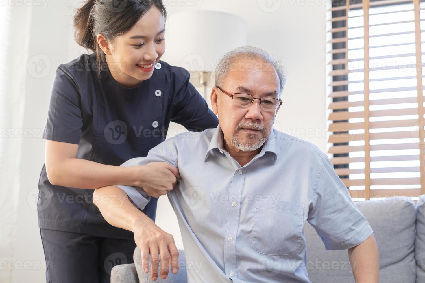 Mature man suffering from bone backache or stiff muscles, young caregiver care supporting elderly, aged pain, cure of grandmother after retirement, help support. Unhealthy posture or uncomfortable photo