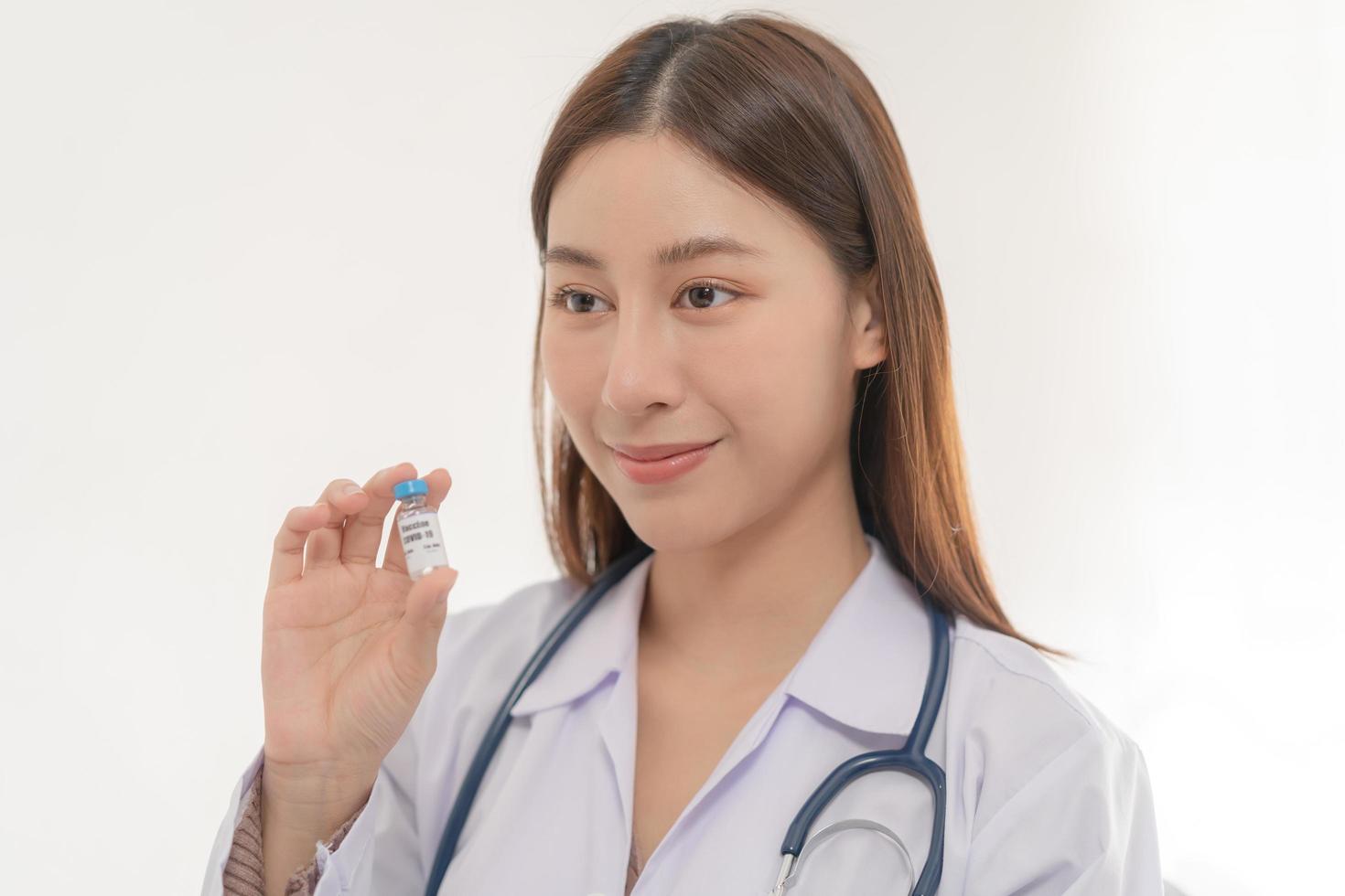 Covid-19, coronavirus hand of asian young woman or female doctor, nurse holding vaccine vial, healthcare and medical. Vaccination, immunization or disease prevention against or virus pandemic concept. photo