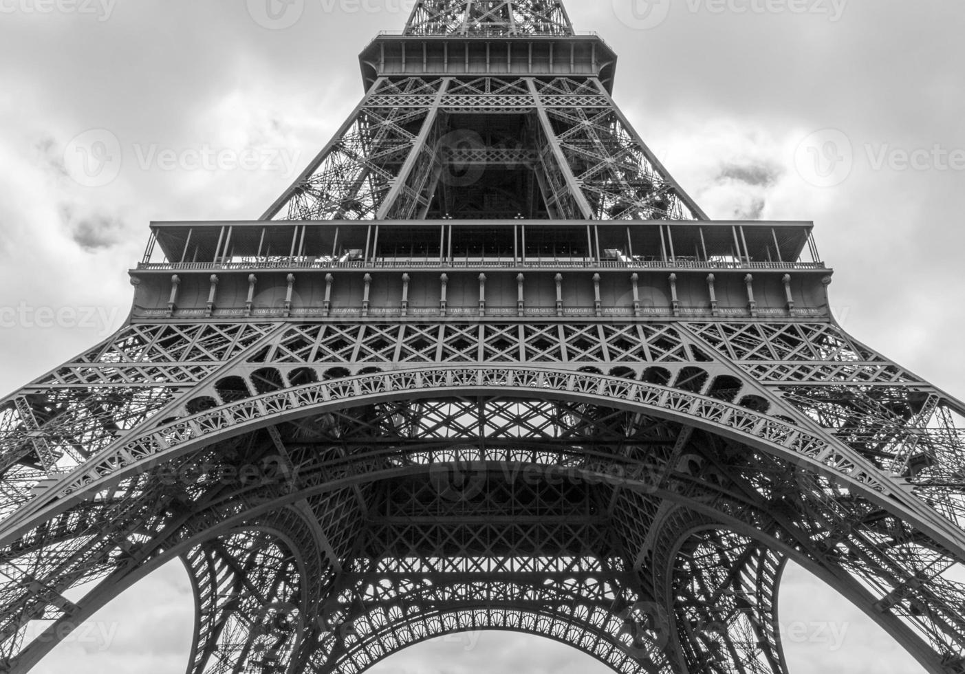 detail of Eiffel tower against clouds in black and white photo