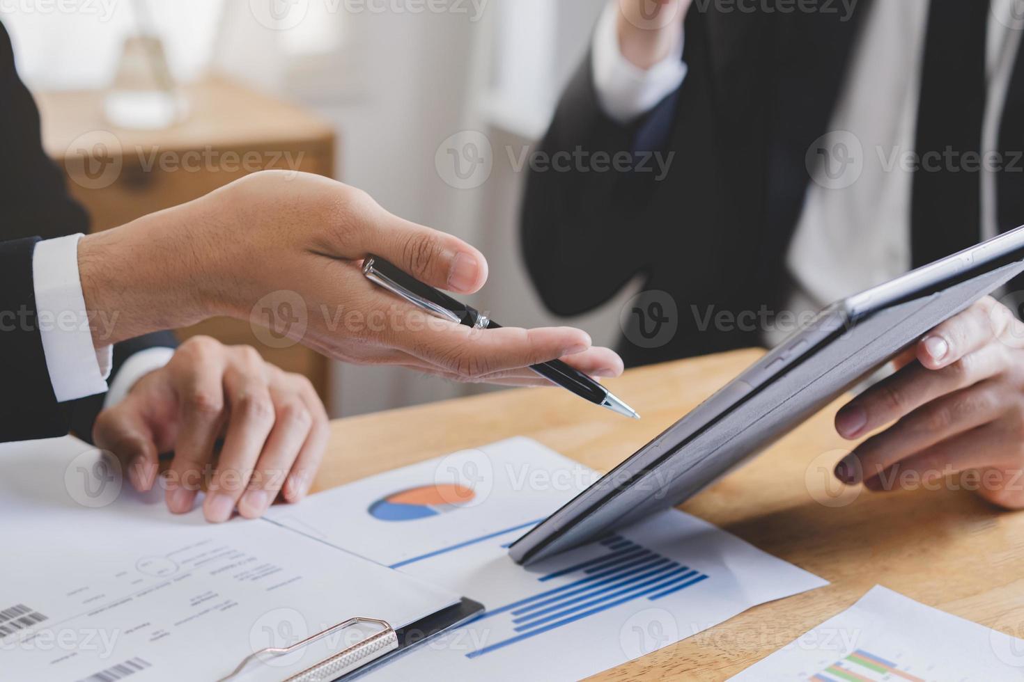 Business meeting, two caucasian, asian group man use tablet brainstorm analyzing on graph data of cost plan or document, paperwork and discussing in board room on table. People working conference room photo