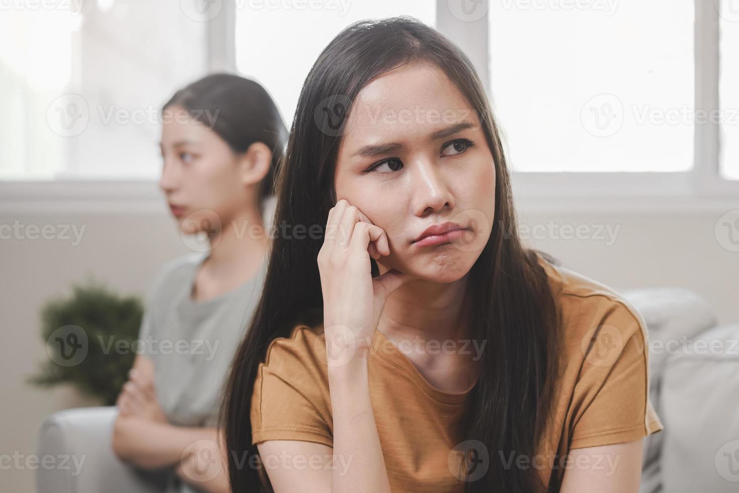 Unhappy lesbian, lgbt asian young two women, girl gay, couple love fight on sofa, relationship is in trouble. Different people are angry and use emotions at each other, expression of disappointmen. photo