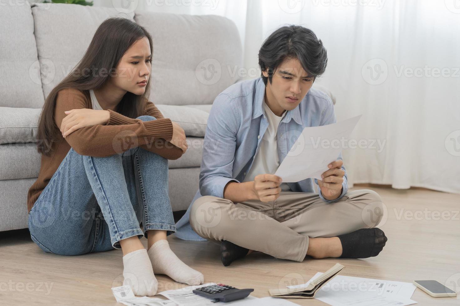 Stressed financial owe asian young couple love sitting suffer, stressed and confused by calculate expense from invoice or bill, no money to pay, mortgage or loan. Debt, bankrupt or bankruptcy people. photo