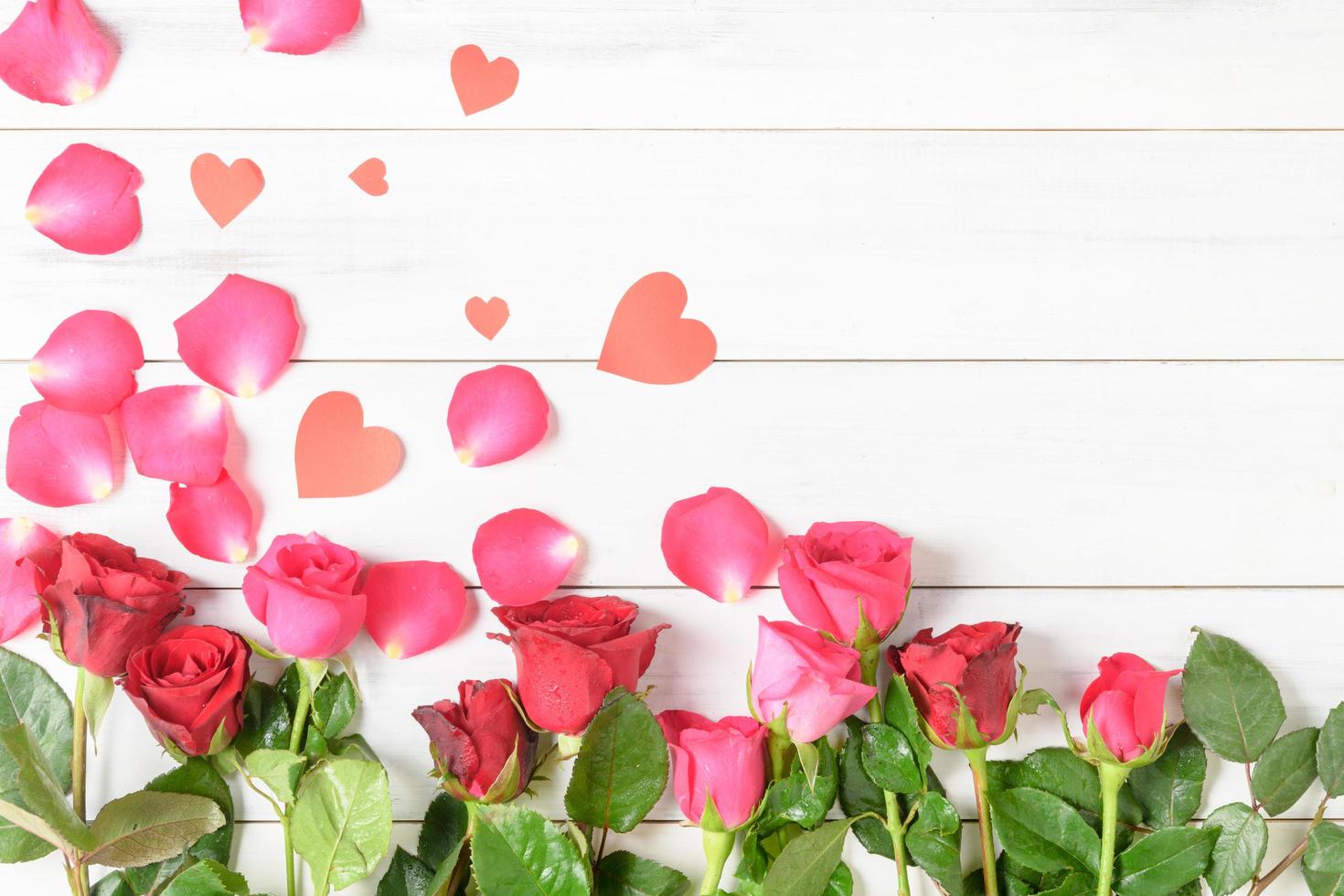 rojo y rosado Rosa con papel corazón en blanco madera antecedentes foto