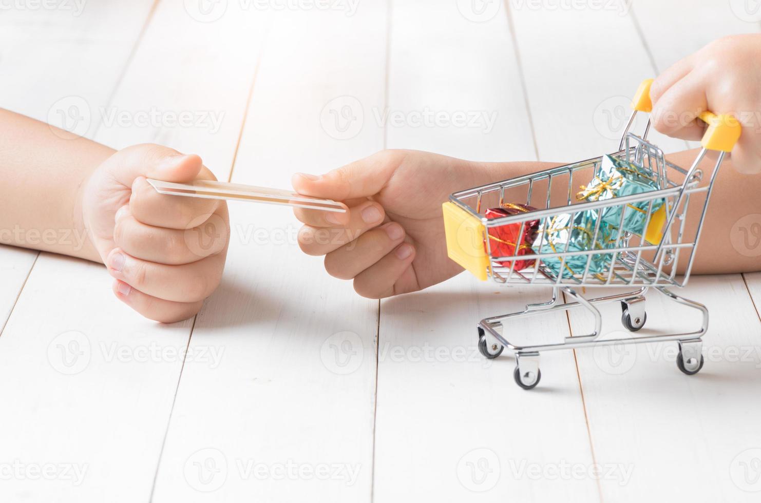 Kid Hands holding credit card and shopping Cart photo