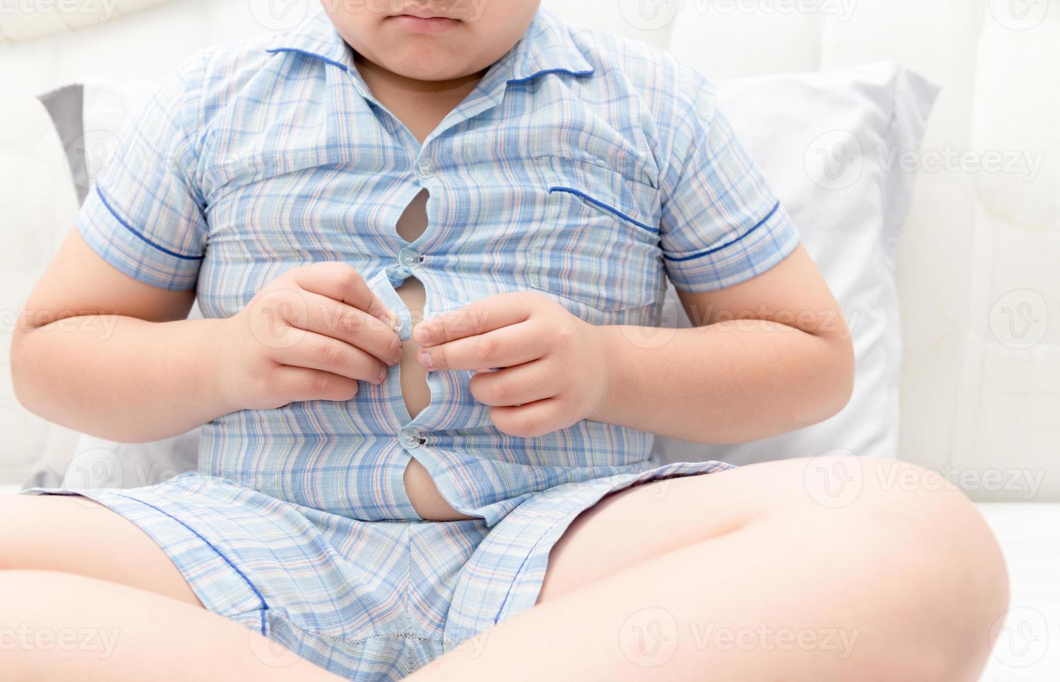 Obese fat boy overweight. Tight shirt of pajamas photo