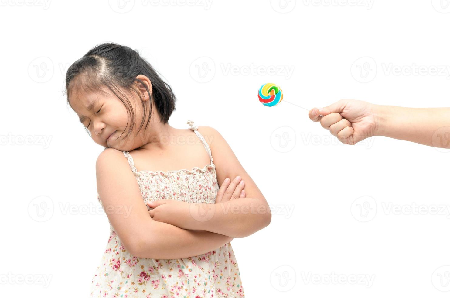 girl with expression of disgust against candy and suffering from toothache photo