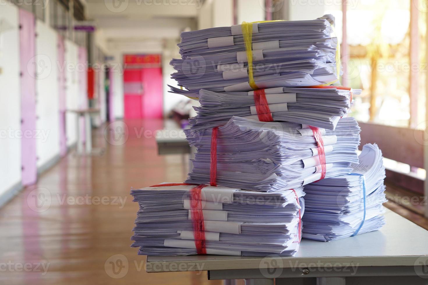 Stack of used paper test after the examination in front of classroom, combine to use next time or take to recycle process. Concept, eco friendly activity. Waste paper management. Reduce reuse, recycle photo