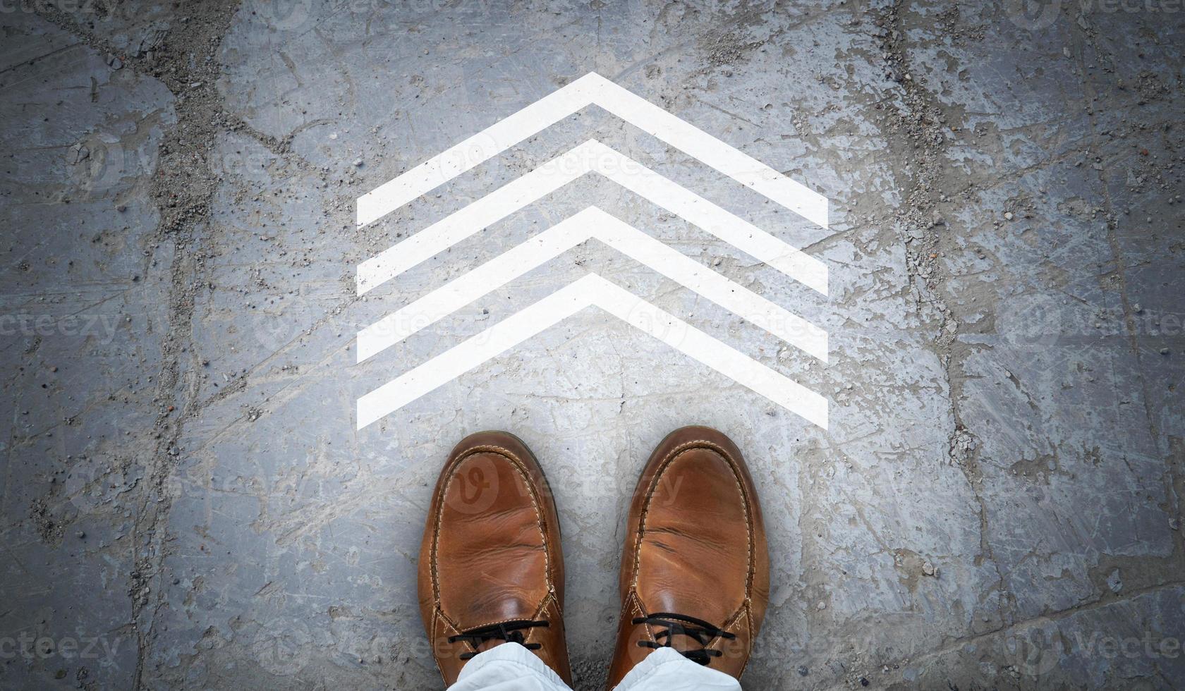 Brown Leather Shoes and One Geometrical Chalky Arrow on Asphalt - Destination Concept photo