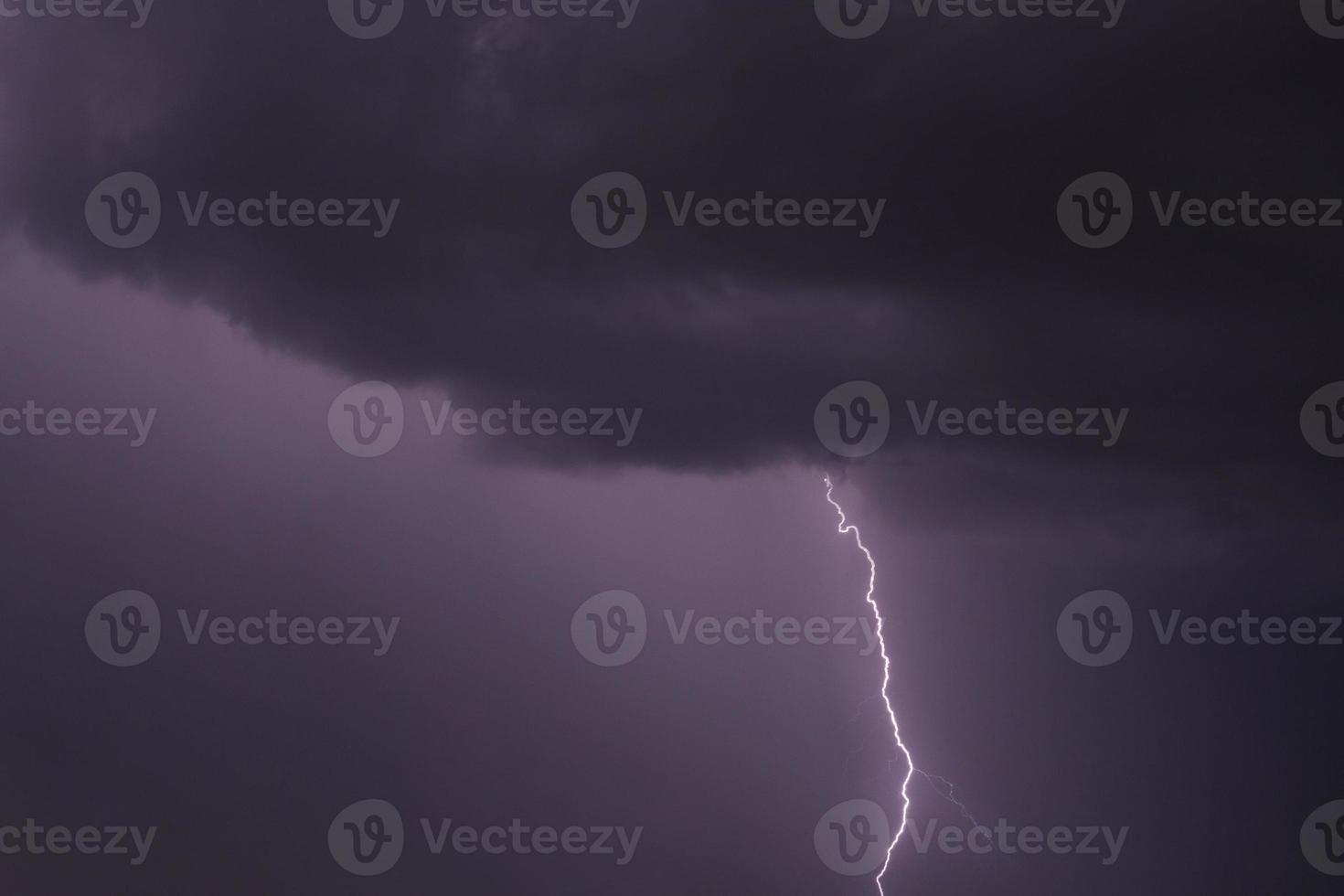 view on lightning striking from rain cloud photo