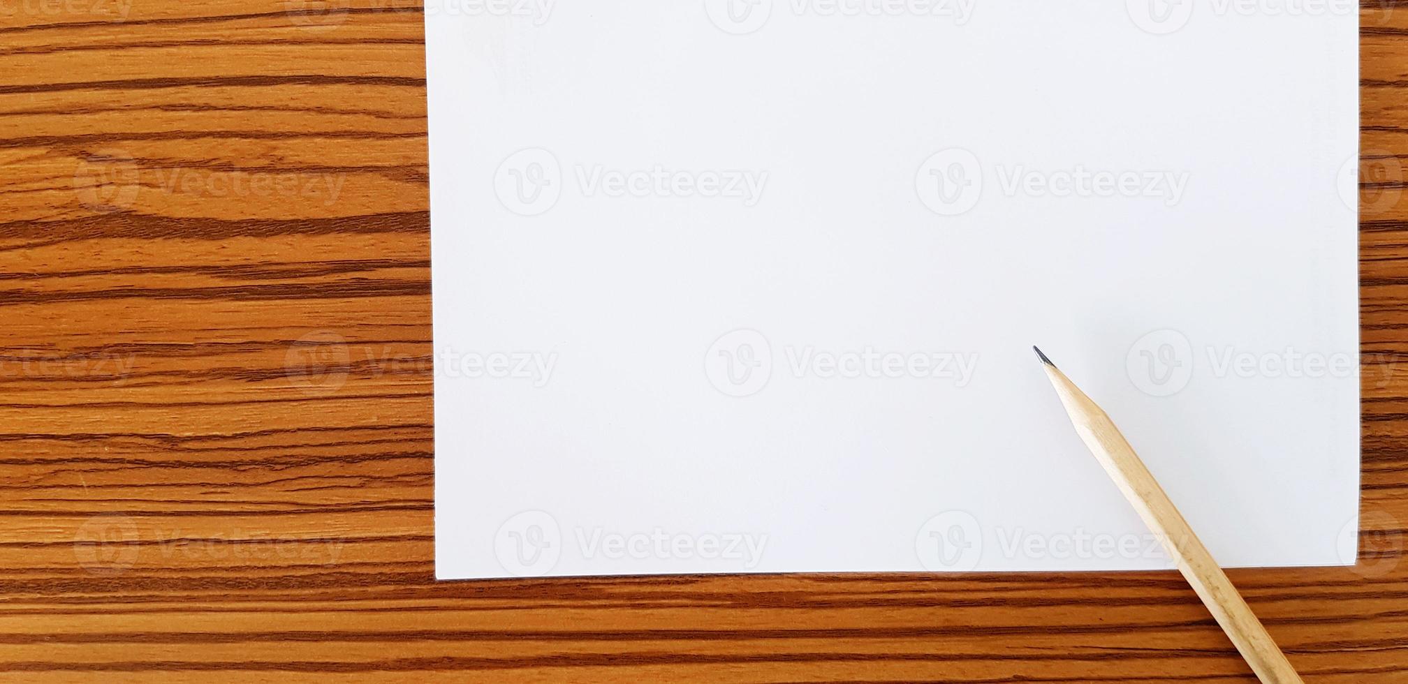 Brown pencil with white paper putting on wooden table with copy space for fill text. Education, Document and Object concept photo