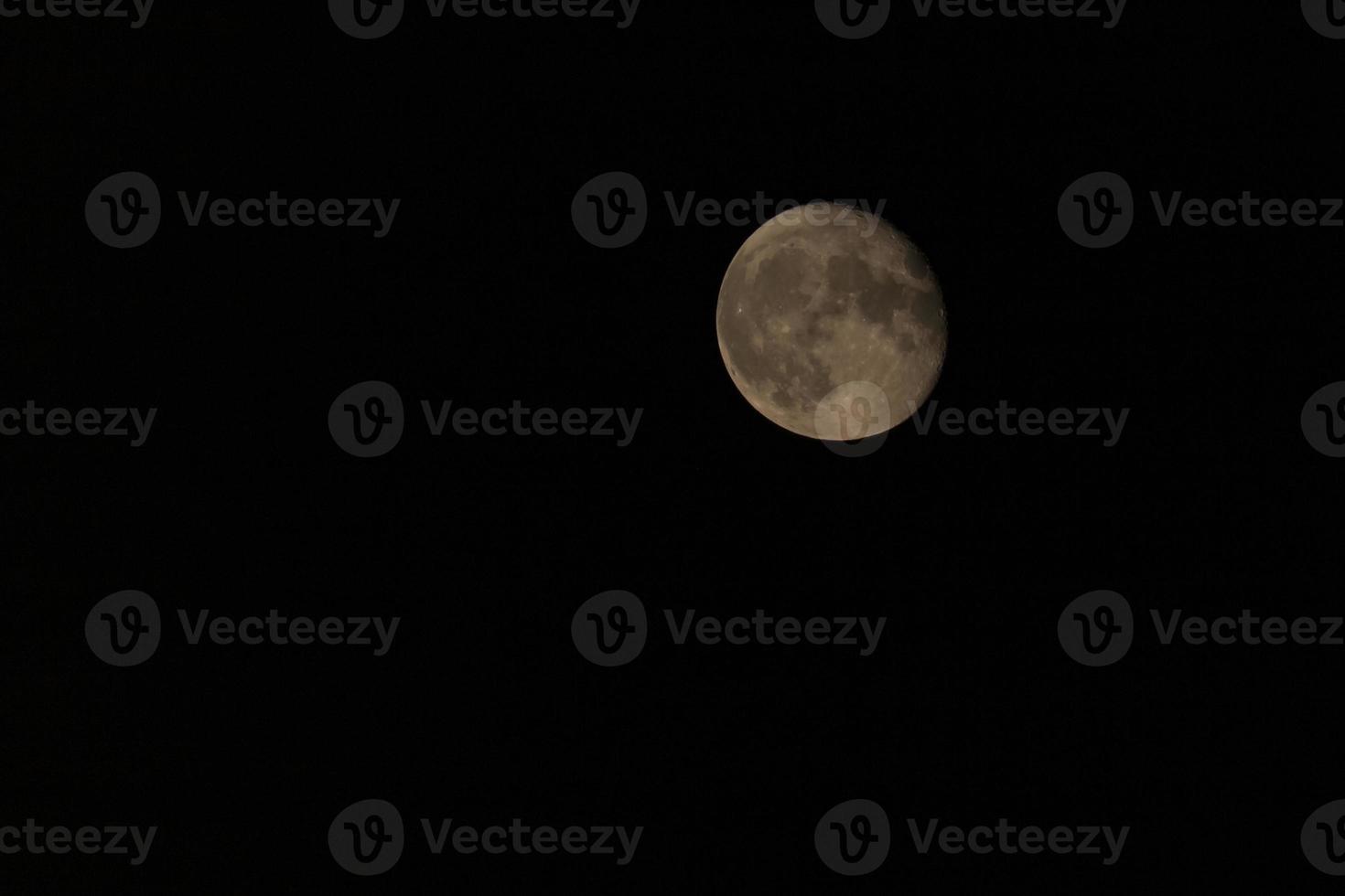 almost full Moon in dark sky photo