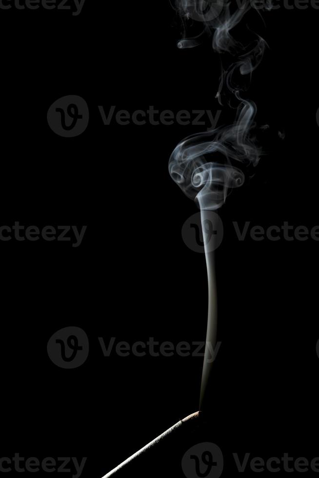 Burning incense stick on a black background photo