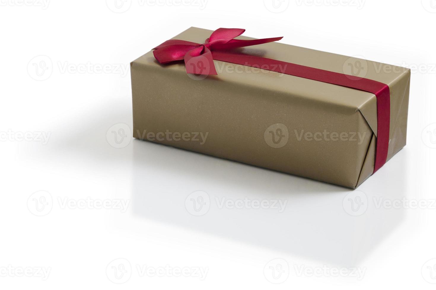 Gold gift with red satin ribbon bow on white background photo