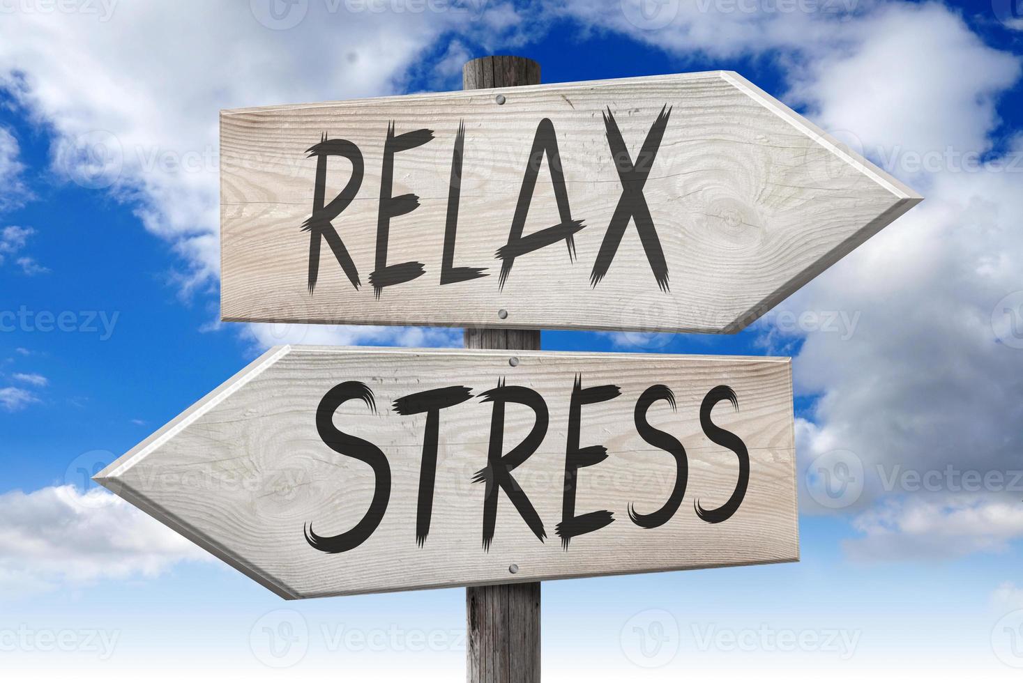 Stress, Relax - Wooden Signpost with Two Arrows and Cloudy Sky in Background photo