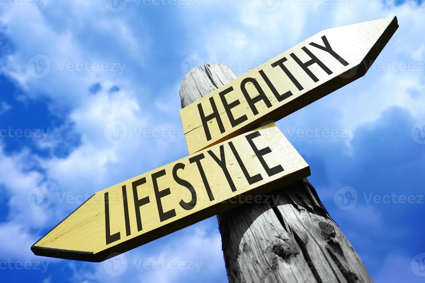 Healthy, Lifestyle - Wooden Signpost with Two Arrows and Sky in Background photo
