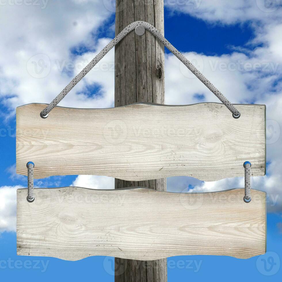 Two Boards Hanging on Post on Ropes with Sky in Background photo